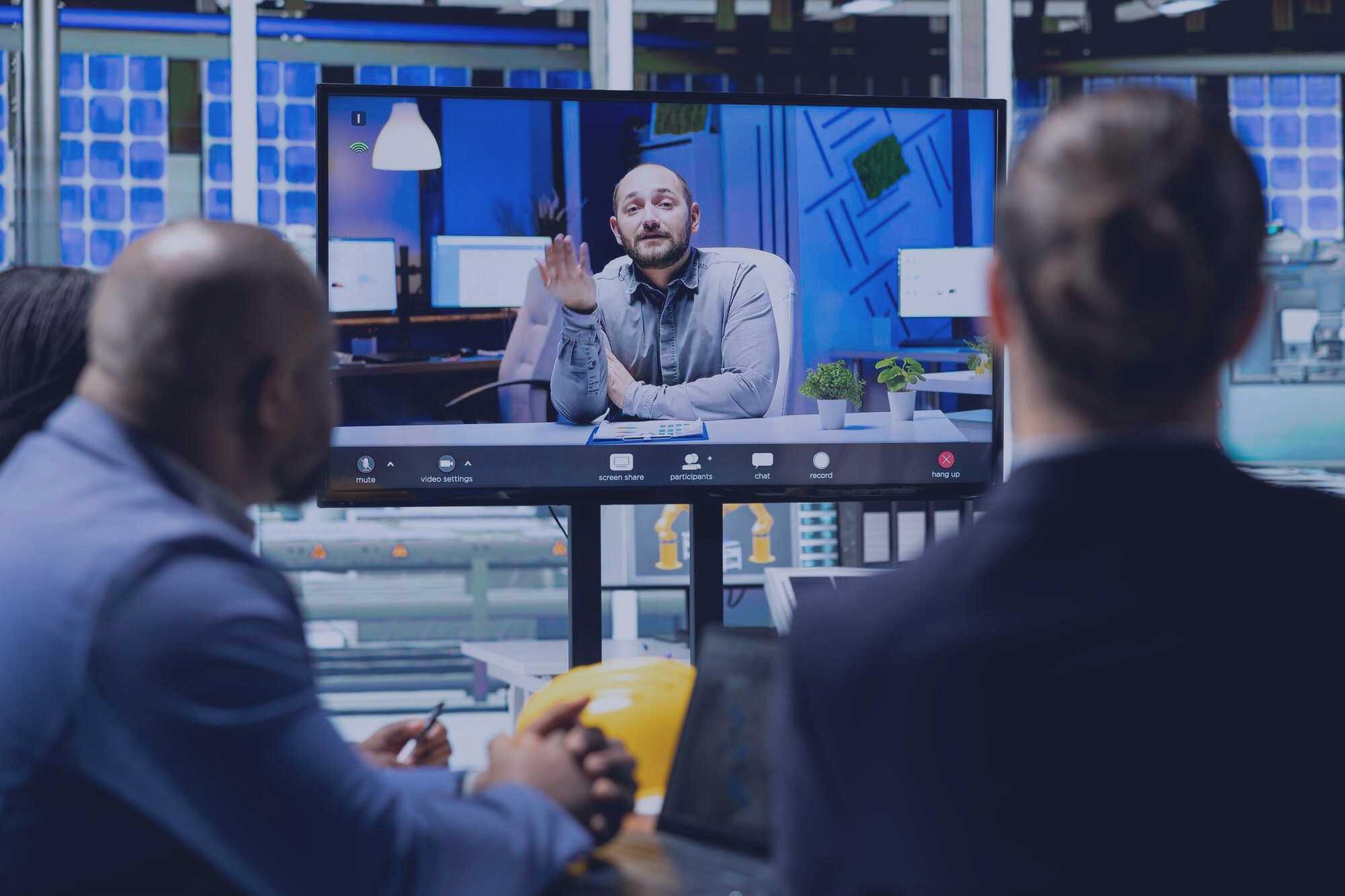 Hybrid team meeting in a dark executive conference room